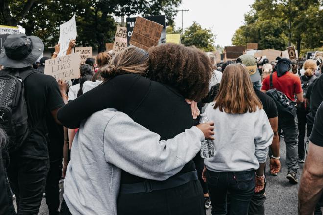 peaceful protestors hugging at a march