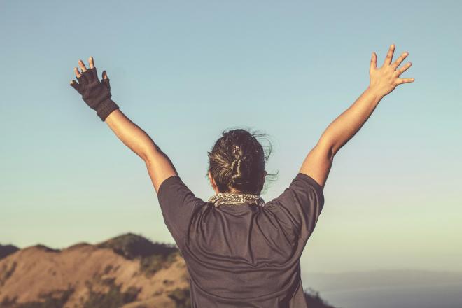 person with their hands above their head in celebration